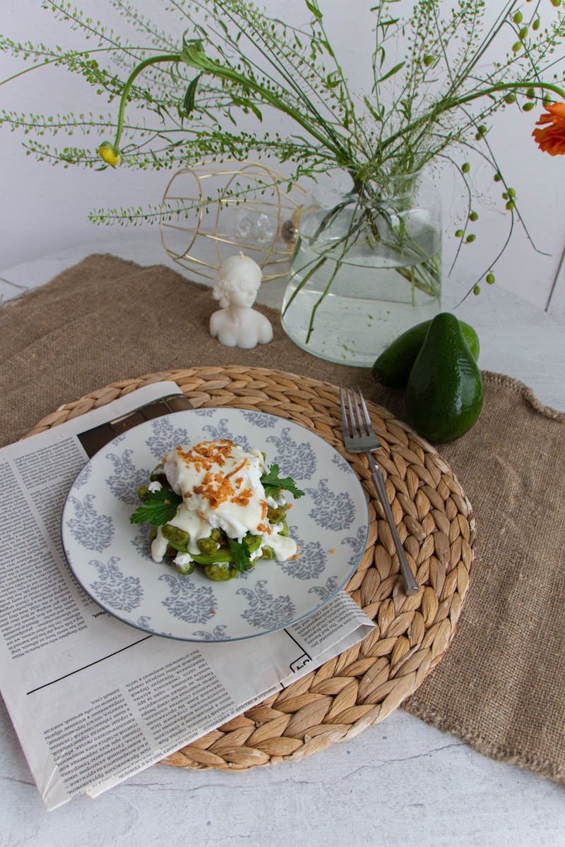 Fresh avocado salad served on a decorative table setting with herbs.